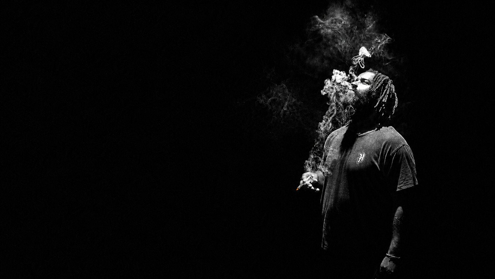 Ricky Williams exhaling smoke in darkness